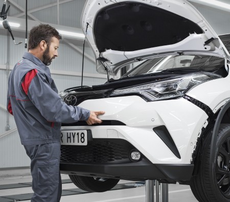 Technician checking car bumper